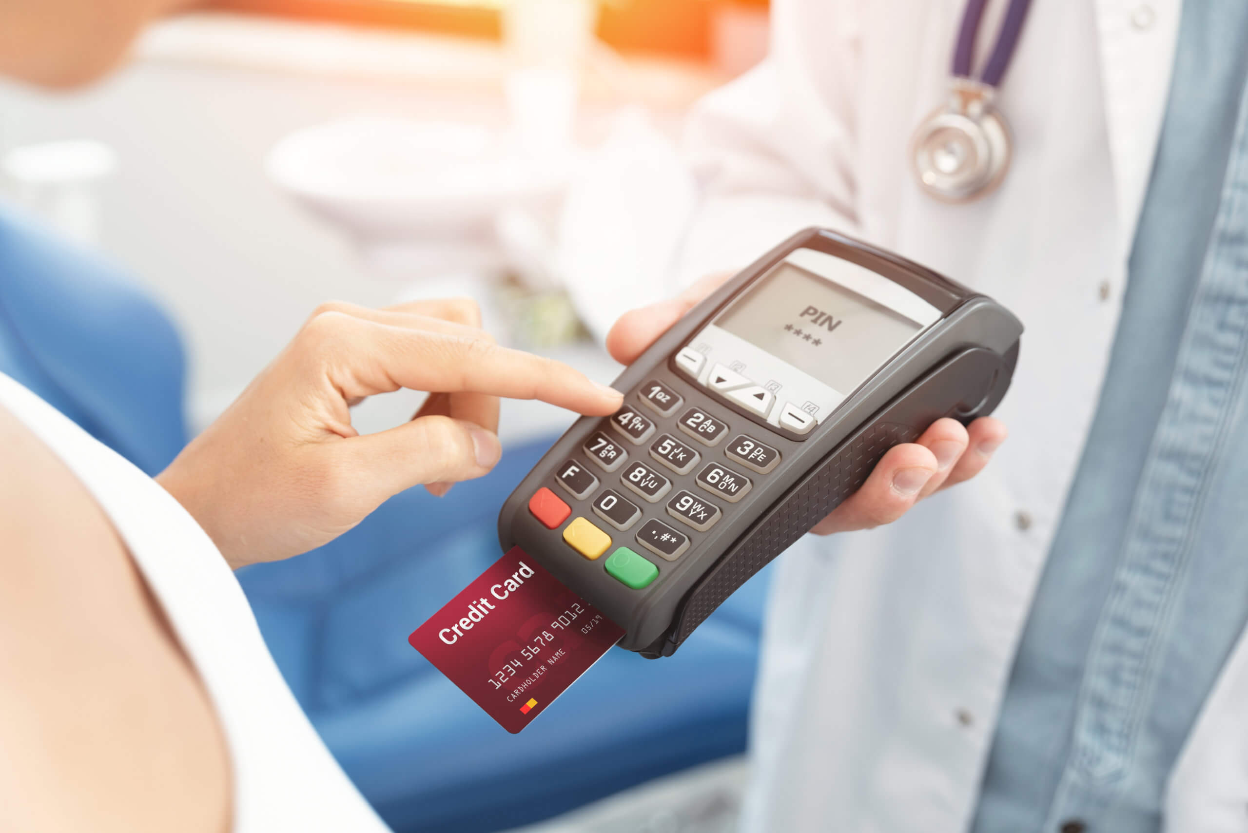 Doctor is holding payment terminal in hands